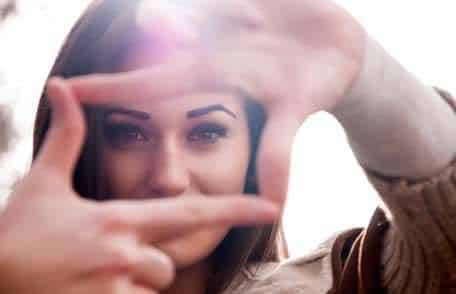 Woman framing her eyes with her fingers