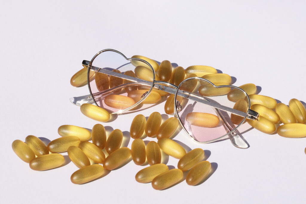 Heart-shaped sunglasses and yellow pills.