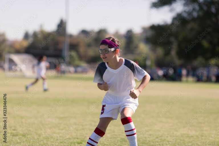 Kid in safety googles on soccer field