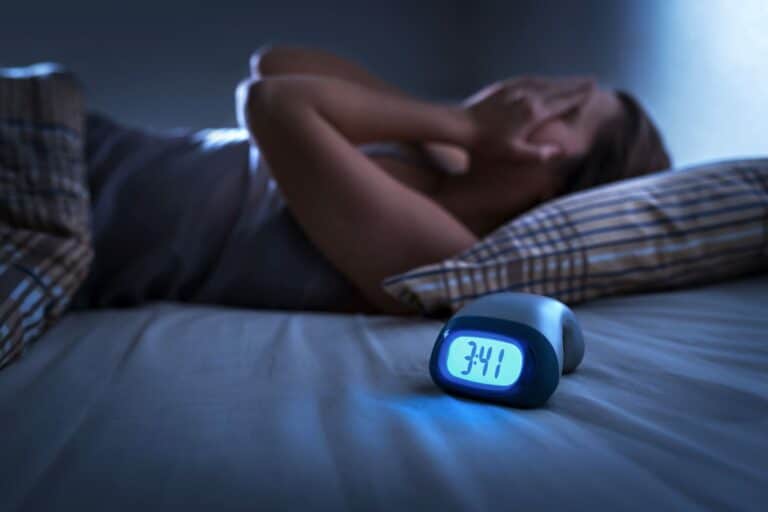 Woman sleeping next to alarm clock