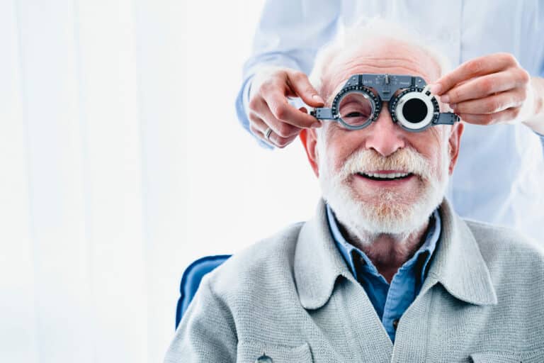 Portrait of a happy mature male patient undergoing vision check with special ophthalmic glasses