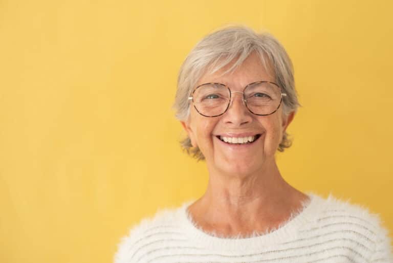 Portrait of beautiful happy senior woman white-haired looking at camera wearing eyeglasses