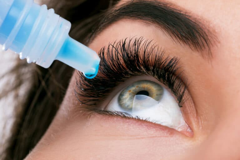 Beautiful woman using eye drops