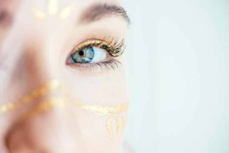 Close up of eyes of young woman with artistic makeup in the form of paint strokes.